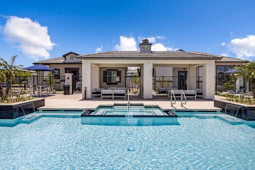 A house with a pool in front of it.