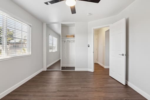 A room with a ceiling fan and a large mirror.