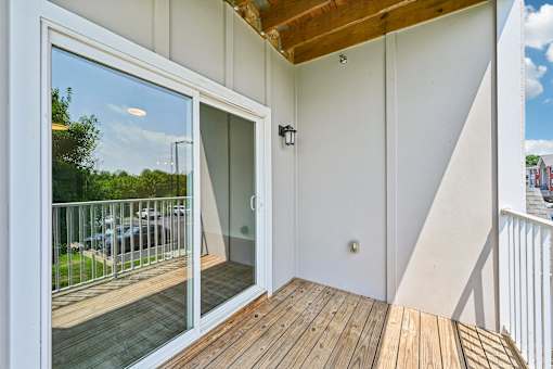 A balcony at Hawks Landing in Hickory NC featuring a sliding glass door and wooden flooring