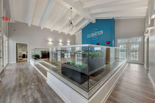 Pet-Friendly Apartments in Sandy Springs – Celebration at Sandy Springs - a lobby with a glass display case and a blue sign