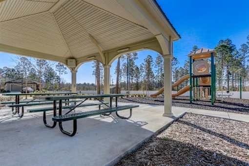a picnic shelter with a playground in the background