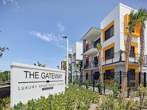 Entrance sign for Gateway Luxury Apartments alongside the sleek exterior of the apartment building.