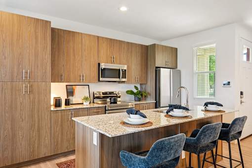 A kitchen with wooden cabinets and a granite countertop.