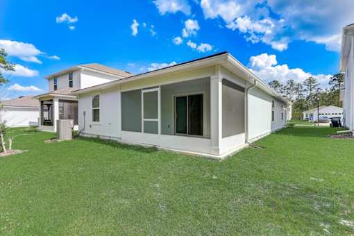 a home with a green lawn and a blue sky in the background