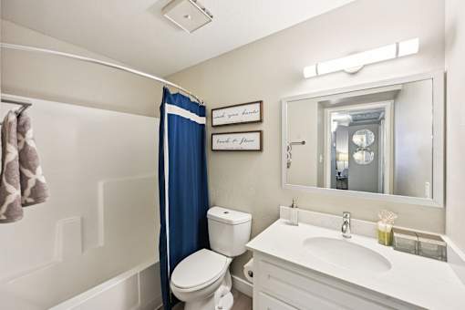 A white bathroom with a toilet, sink, and shower.