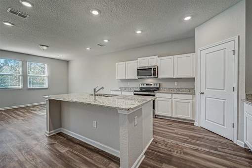 a kitchen with an island and white cabinets