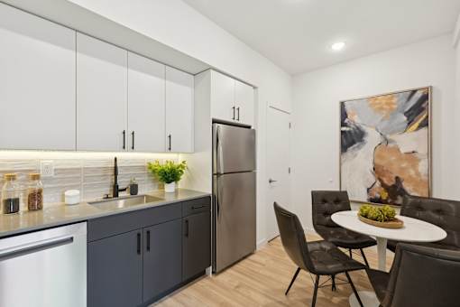 A modern kitchen with a dining table set for two.