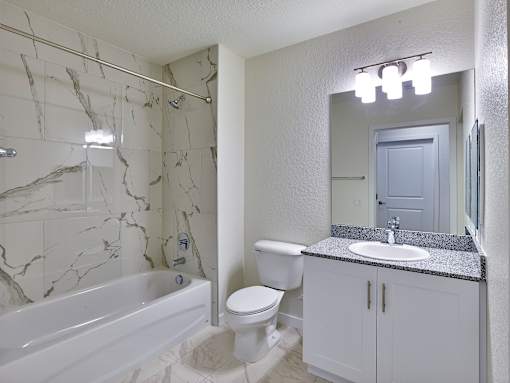 Luxury tub and shower combo in a stylish bathroom at Gateway Luxury Apartments, combining comfort and modern aesthetics.