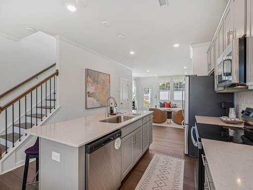Bright dining area and kitchen with stainless steel appliances at The Maple Raleigh townhomes