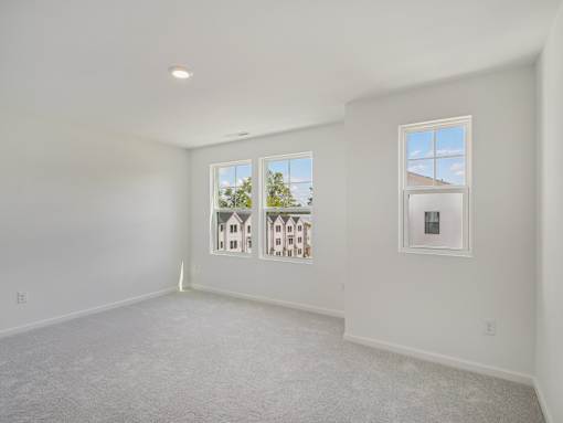 Large bedroom with windows and plush carpeting in The Maple 3-bedroom townhomes Raleigh NC