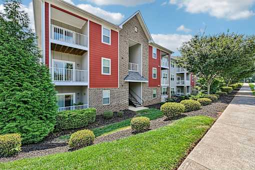 red and beige Hawks Landing apartment buildings in Hickory NC with green bushes in front