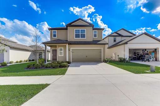 a large house with a garage and a blue sky in the background