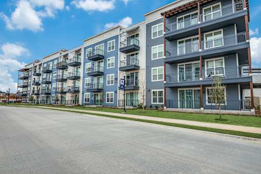 A row of modern apartment buildings with balconies and a clear blue sky.