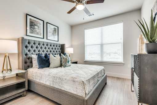 A bedroom with a large bed and a ceiling fan.