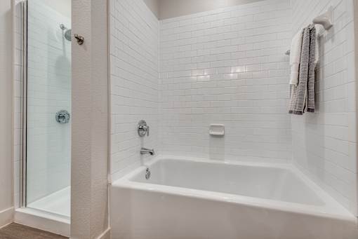 A white bathroom with a white tub and a white shower.