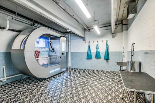 A room with a large circular window and a metal table.