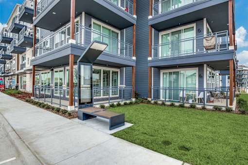 A modern apartment building with balconies and glass doors.