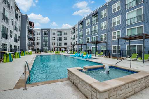 A swimming pool in front of apartment buildings.