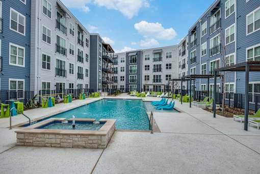 A swimming pool in a courtyard surrounded by apartment buildings.