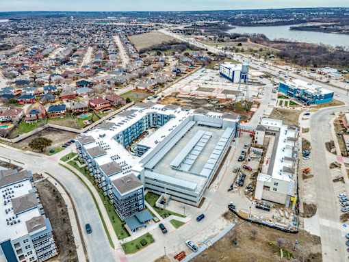 A large building complex is under construction in the middle of a residential area.