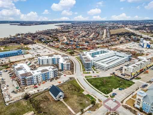 A bird's eye view of a city with buildings, roads, and a body of water.