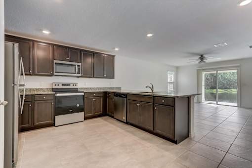 a kitchen with brown cabinets and a white tile floor
