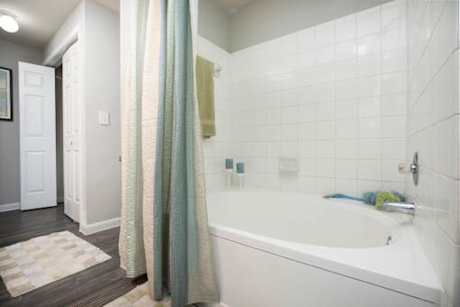 a white bathroom with a tub and a shower