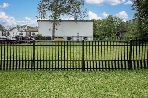 A black fence in front of a white building.