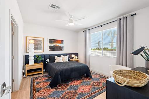 A bedroom with a large bed and a ceiling fan.