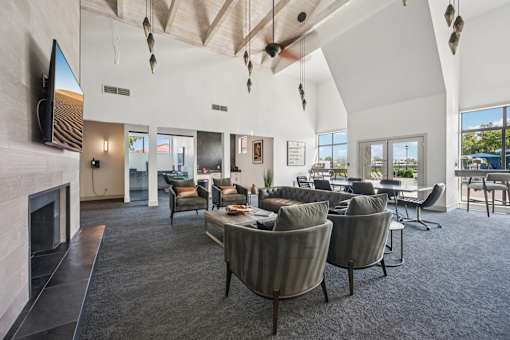 A modern living room with a fireplace and grey chairs.