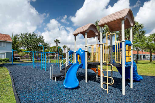 A playground with a blue slide and yellow railings.
