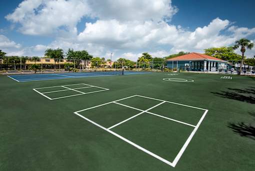 A tennis court with a white net and green surface.