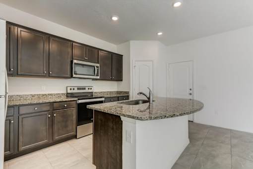 a kitchen with brown cabinets and a granite counter top