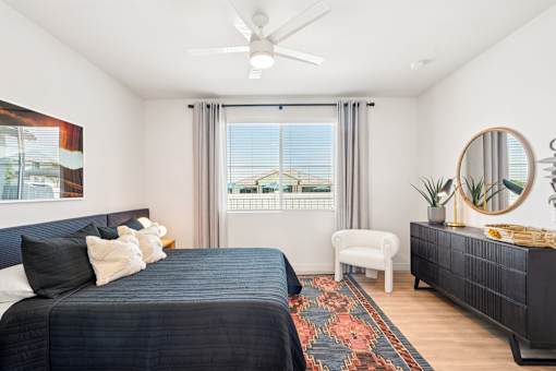 A bedroom with a large bed and a window with a view of the city.