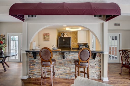 Derby Park Apartments in Daytona Beach, FL photo of a kitchen with a bar and two chairs in the clubhouse