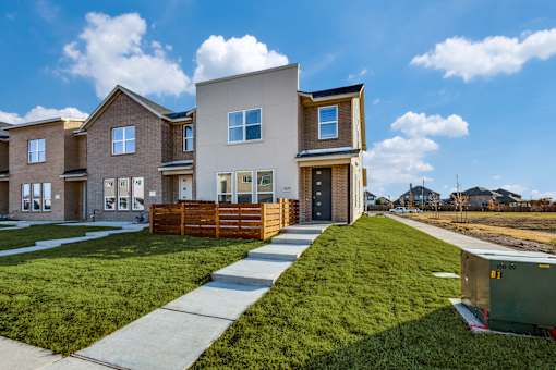 A modern house with a well-maintained lawn and a clear sky.