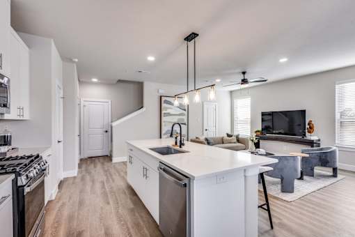 A modern kitchen with a large island and stainless steel appliances.
