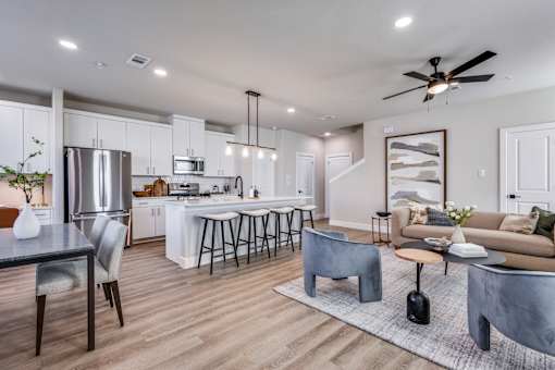 A modern kitchen with a dining table and a living room area.