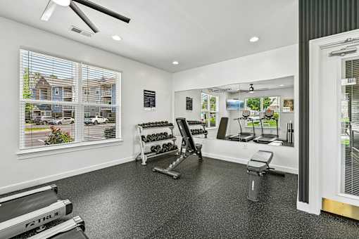 A spacious Hawks Landing fitness center in Hickory NC featuring dumbbells, weight machines, and a treadmill
