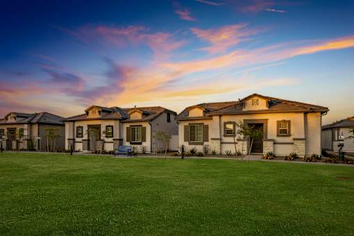 A row of houses with a green lawn in front.