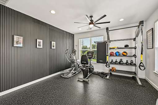 A home gym with a variety of equipment including a treadmill, weights, and a pull-up bar.