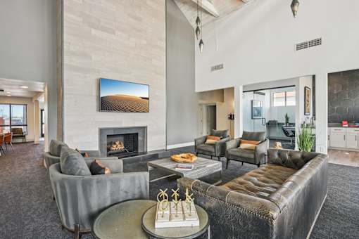 A living room with a fireplace and a painting of a desert landscape on the wall.