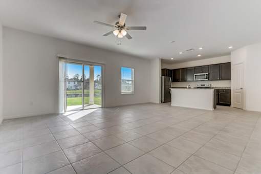 a kitchen and living room with a sliding glass door