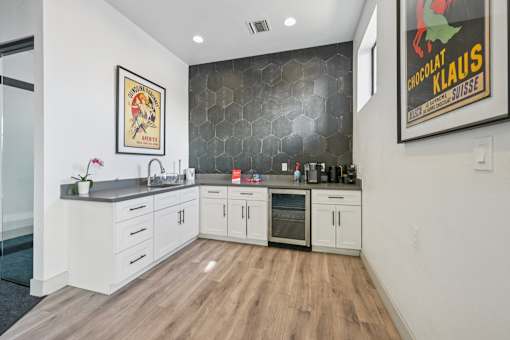 A kitchen with white cabinets and a wooden floor.