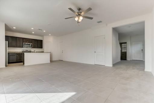 a kitchen and living room with a ceiling fan