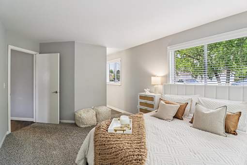 Bright bedroom with plush bedding and natural light at Ashford at Geneva – pet-friendly apartments in Geneva, Illinois
