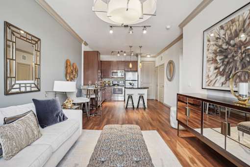 A modern living room with a white couch and a large painting on the wall.