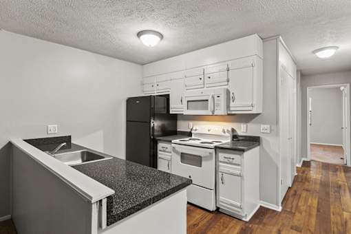 Element at 3900, Macon Apartments A kitchen with black appliances and white cabinets.