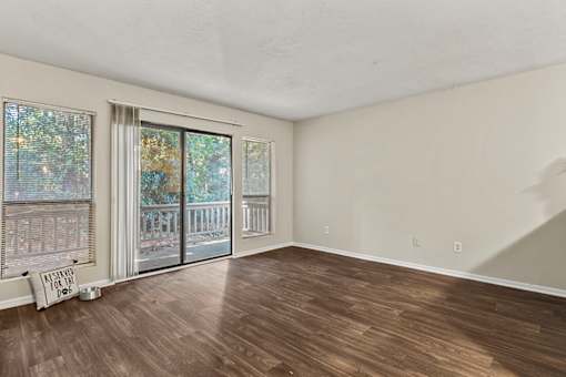 A room with wooden floors and a sliding glass door.