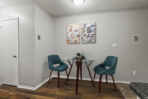 A dining room with a table and two chairs.